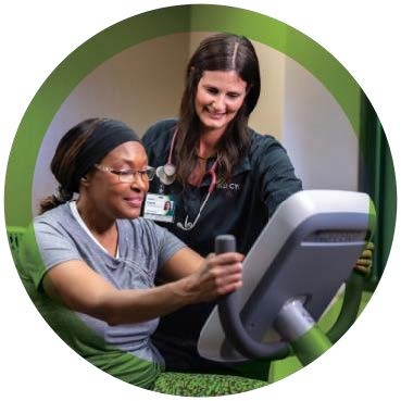 A care team member supporting a patient during exercise.